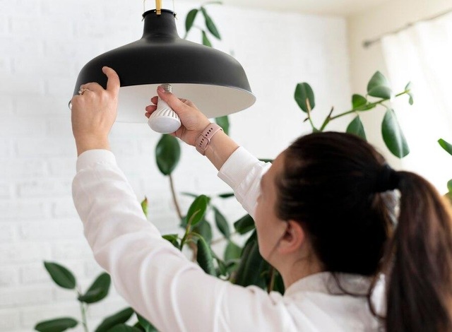 woman changing the light bulb