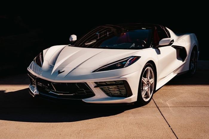 White Chevrolet Corvette in sunlight showcasing modern performance design.