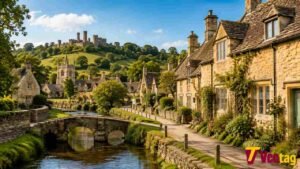 Cotswolds village with stone cottages, bridge, countryside and castle ruins