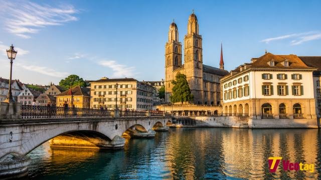 Limmat River Zurich waterfront with Grossmünster towers and historic buildings