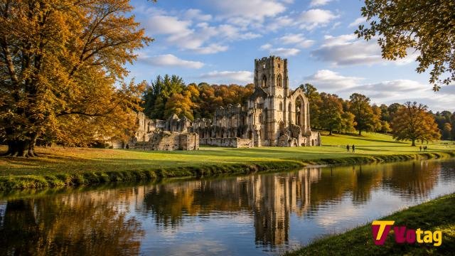 Fountains Abbey and Studley Royal Water Garden reflected in the River Skell during an autumn afternoon