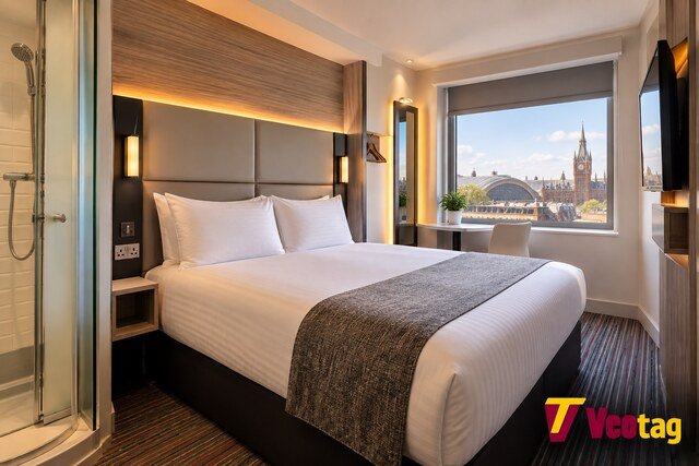 Modern Point A Kings Cross hotel room with double bed, glass shower, and London view near King’s Cross Station.