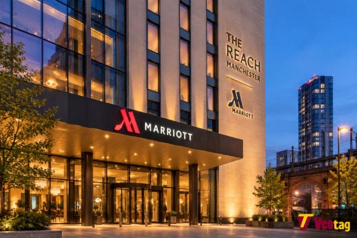 The Reach Manchester Marriott hotel exterior illuminated at dusk in Manchester.