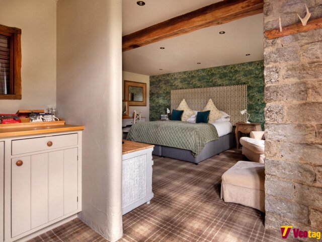 Cozy guest room at The Star Inn Harome featuring a double bed, rustic wooden beams, stone walls, and elegant country-style furnishings.