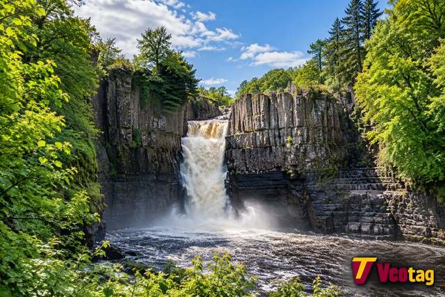 High Force waterfall surrounded by lush woodland, with the Veotag logo in the bottom-right corner.
