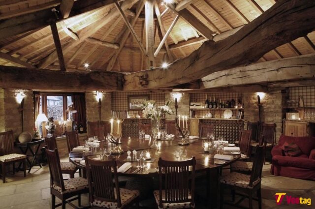 Rustic dining room at The Star Inn at Harome featuring exposed wooden beams, stone walls, candlelit tables, and traditional country inn charm.